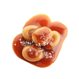 Photo of Yummy candies with caramel sauce and sea salt isolated on white, top view