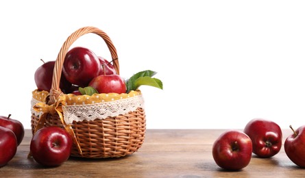 Photo of Fresh ripe red apples and green leaves on wooden table. Space for text