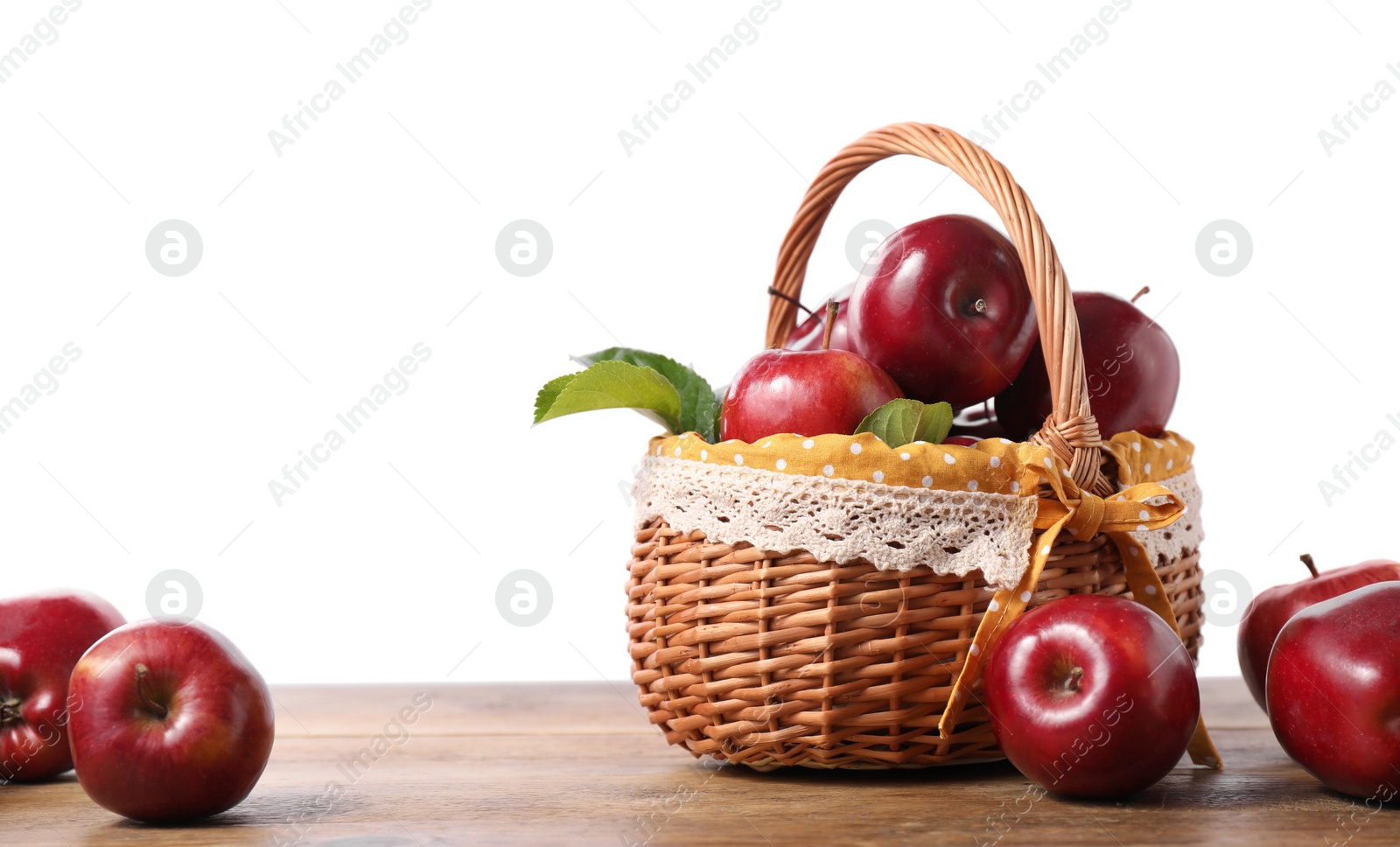 Photo of Fresh ripe red apples and green leaves on wooden table. Space for text