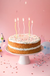 Photo of Tasty cake with colorful candles on pink background
