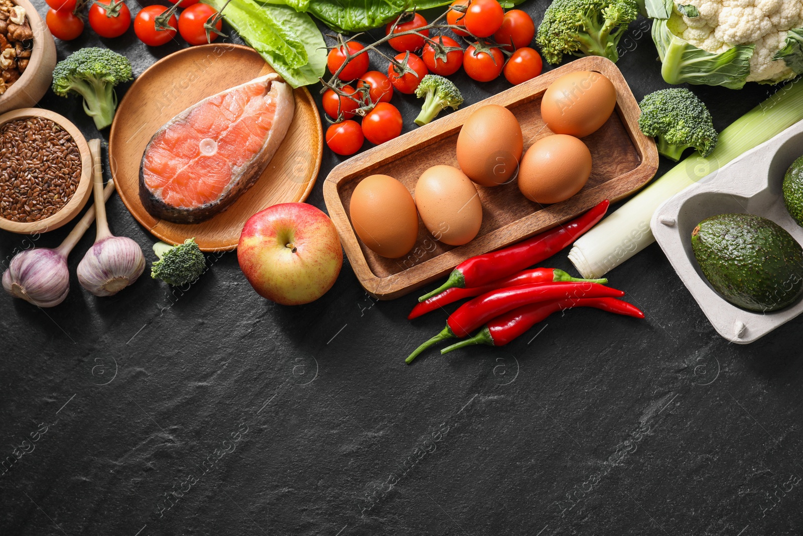 Photo of Many different healthy food on dark textured table, flat lay. Space for text