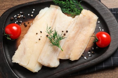 Photo of Raw cod fish, dill, tomatoes and spices on wooden table, top view