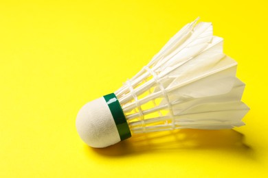 One feather badminton shuttlecock on yellow background