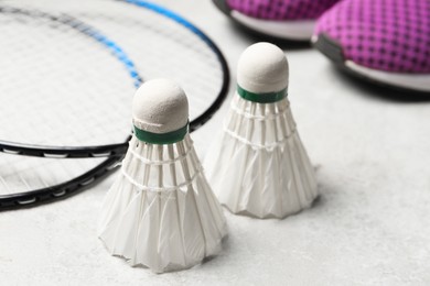 Photo of Feather badminton shuttlecocks and rackets on gray background, closeup