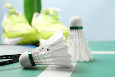 Two feather badminton shuttlecocks on court, closeup