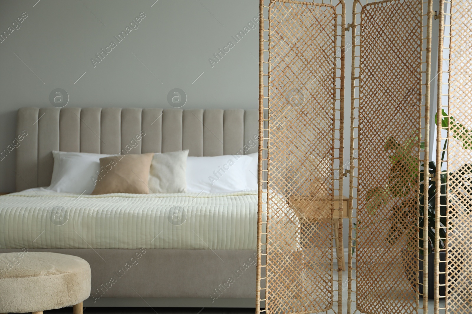 Photo of Folding screen and comfortable bed in bedroom. Interior design