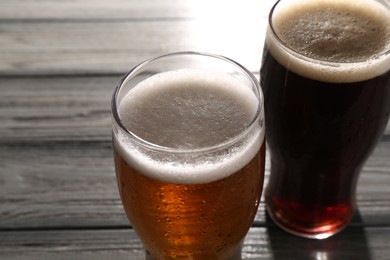 Glasses with different types of beer on grey wooden table, closeup