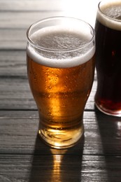 Glasses with different types of beer on grey wooden table, closeup