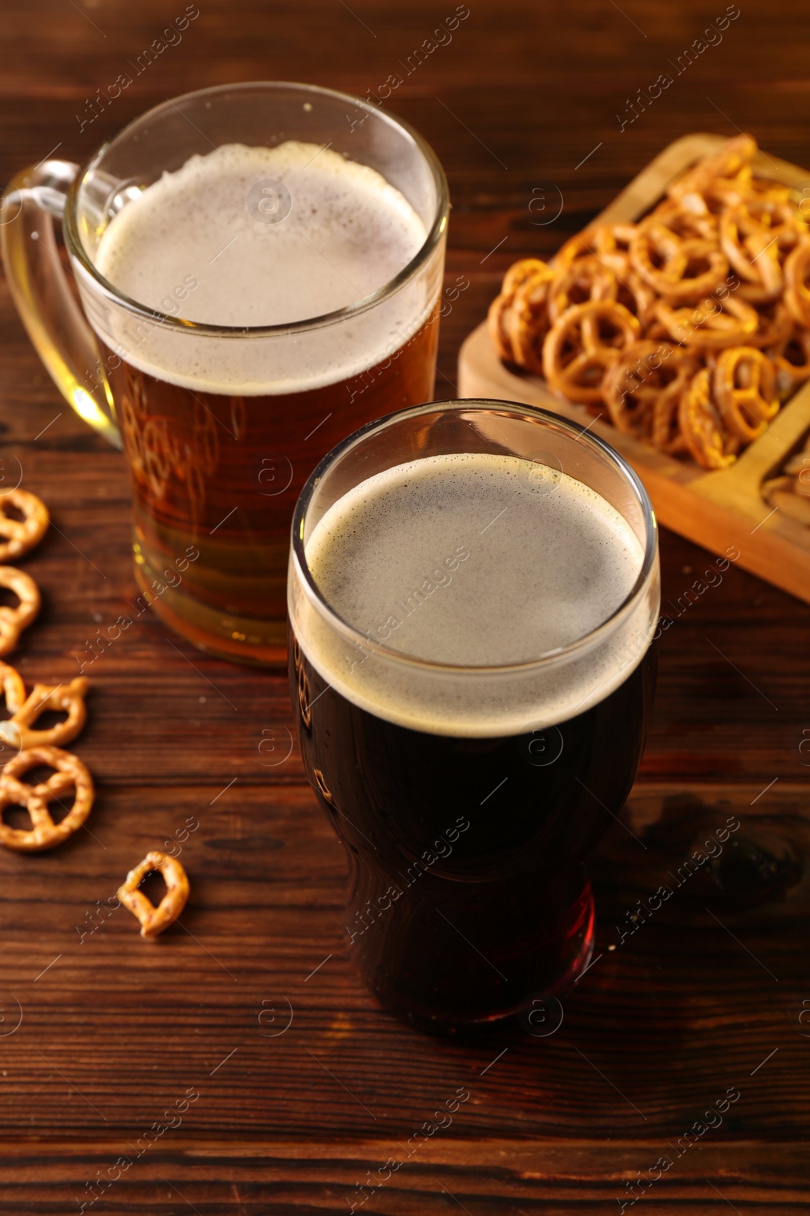 Photo of Glasses with different types of beer and snacks on wooden table