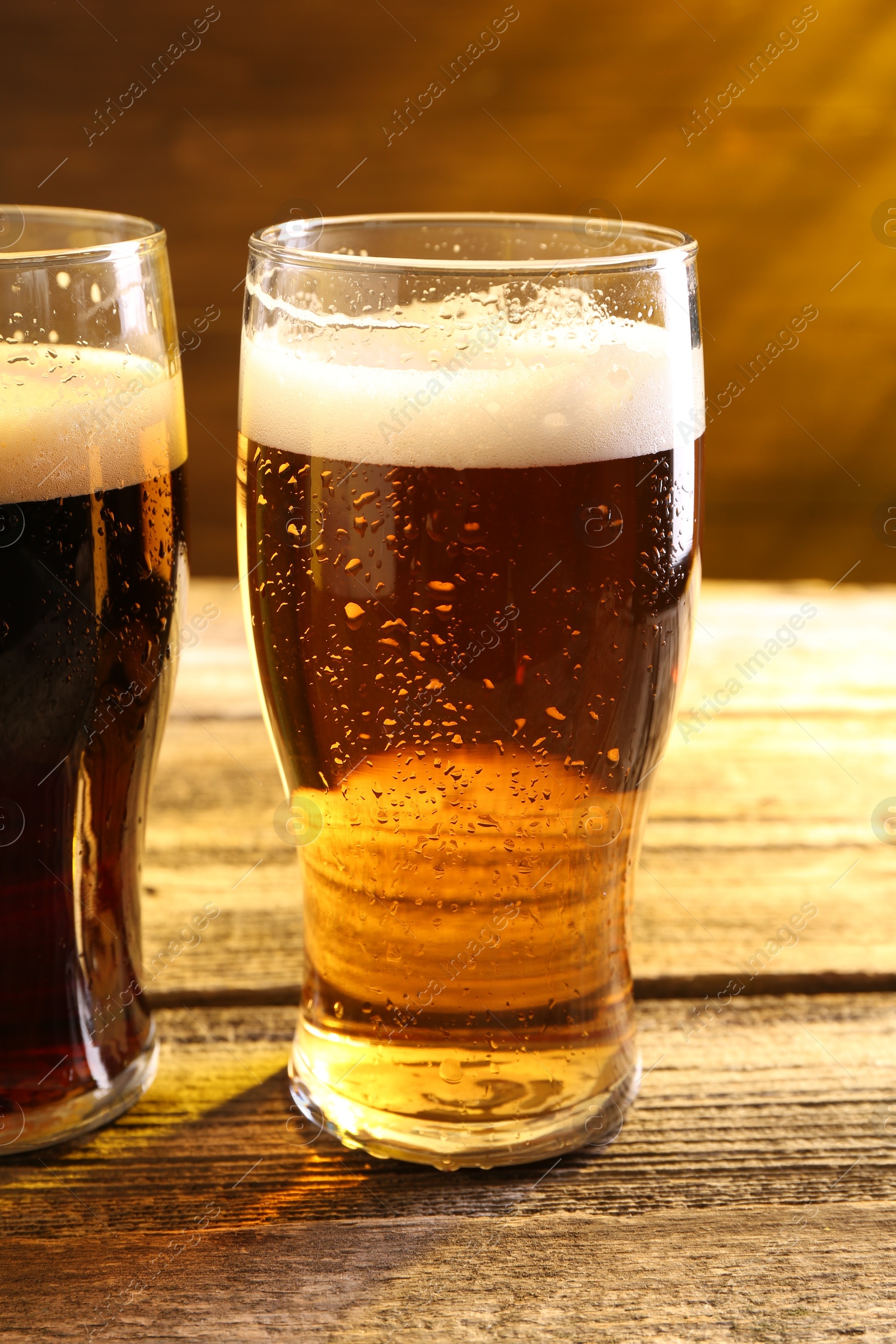 Photo of Glasses with different types of beer on wooden table, closeup
