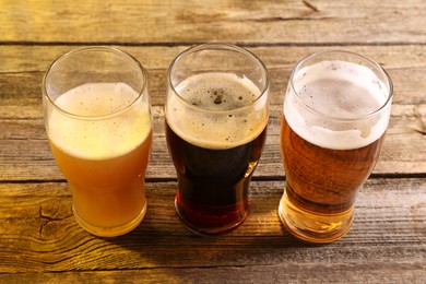 Photo of Glasses with different types of beer on wooden table