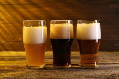 Glasses with different types of beer on wooden table