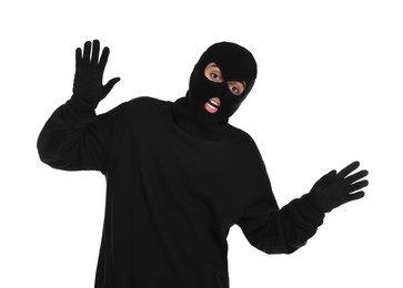 Photo of Emotional thief in balaclava raising hands on white background