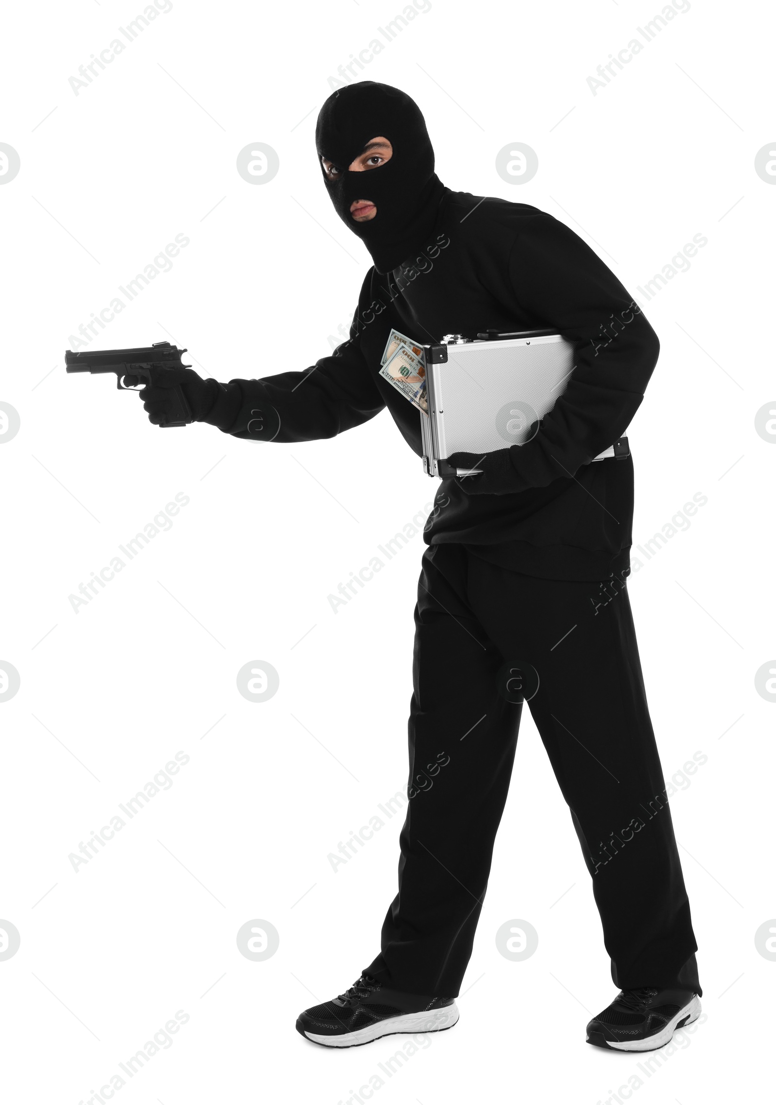 Photo of Thief in balaclava with gun and briefcase of money on white background