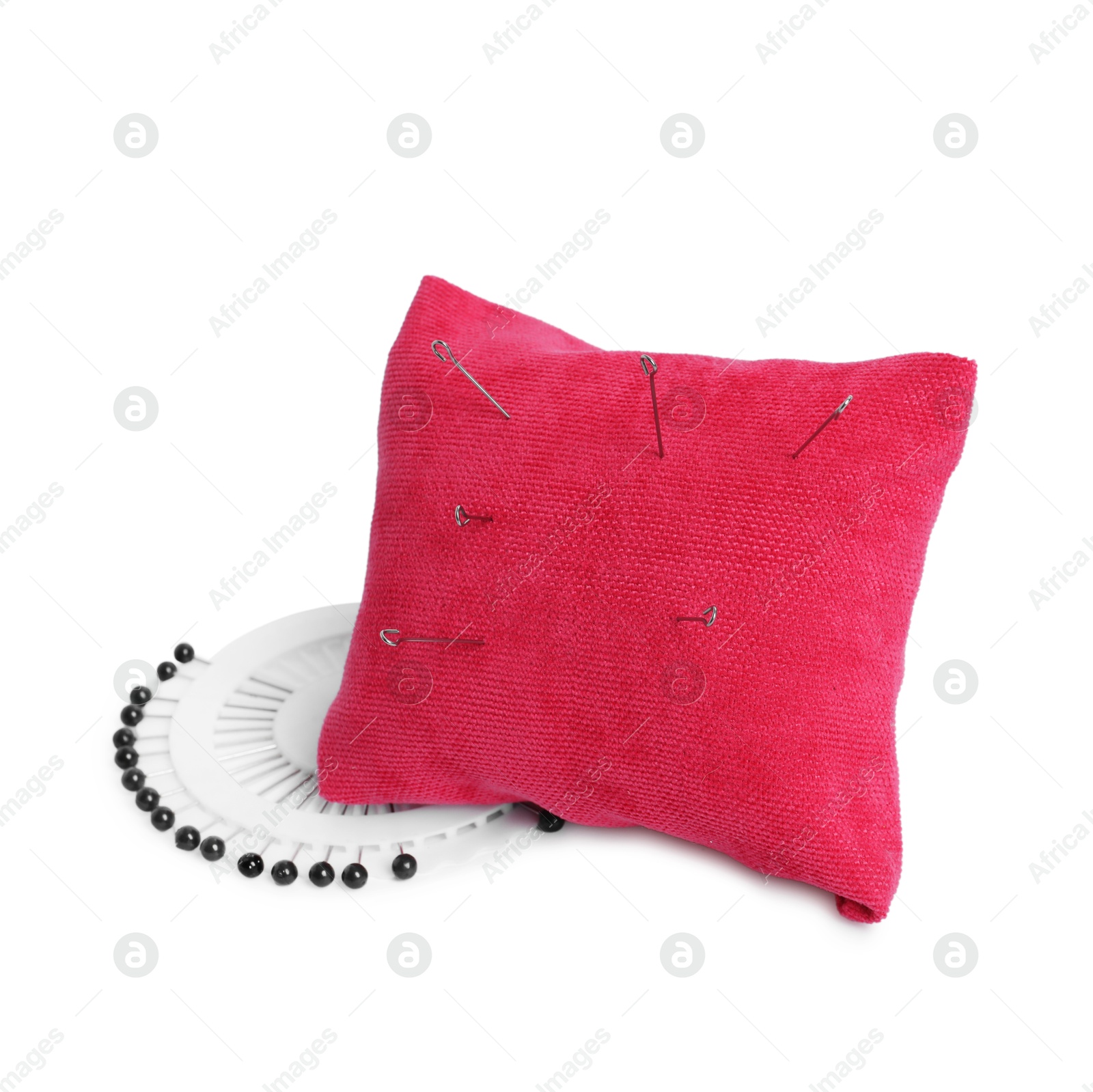 Photo of Pink pincushion with sewing needles and pins isolated on white