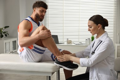 Photo of Sports injury. Doctor examining patient's leg in hospital
