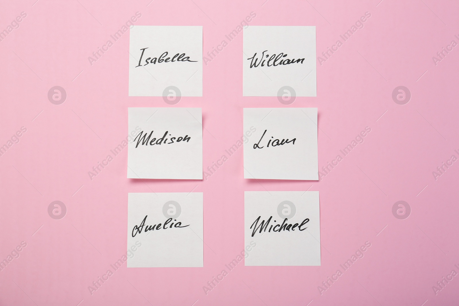 Photo of Paper stickers with different names on pink background, flat lay. Choosing baby's name