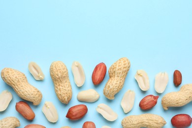 Fresh peanuts on light blue background, flat lay. Space for text