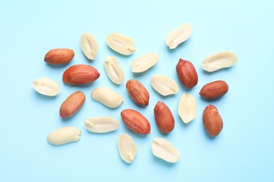 Fresh peanuts on light blue background, flat lay