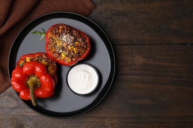 Photo of Quinoa stuffed peppers with corn on wooden table, top view. Space for text