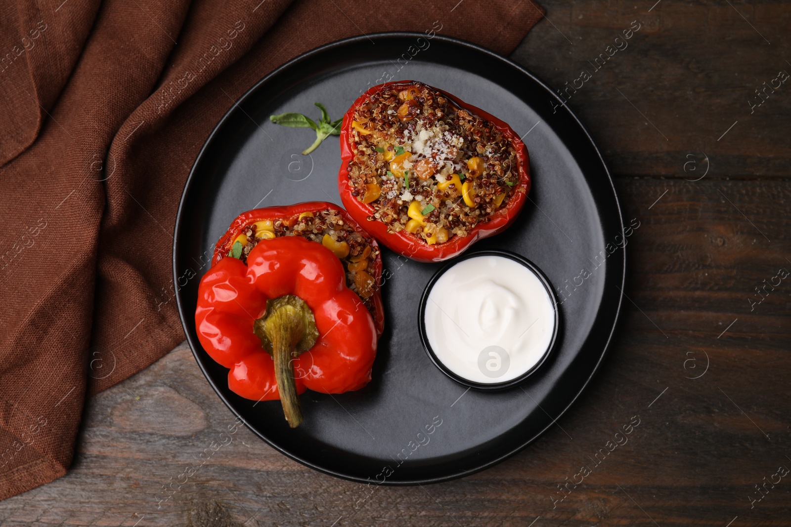 Photo of Quinoa stuffed peppers with corn on wooden table, top view