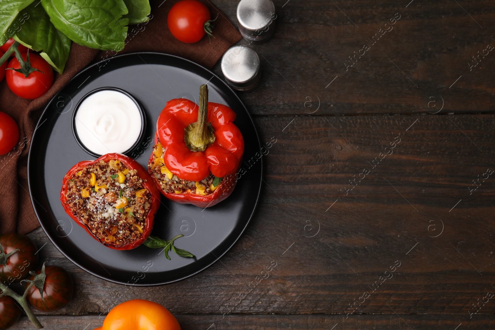 Photo of Quinoa stuffed peppers with corn on wooden table, flat lay. Space for text