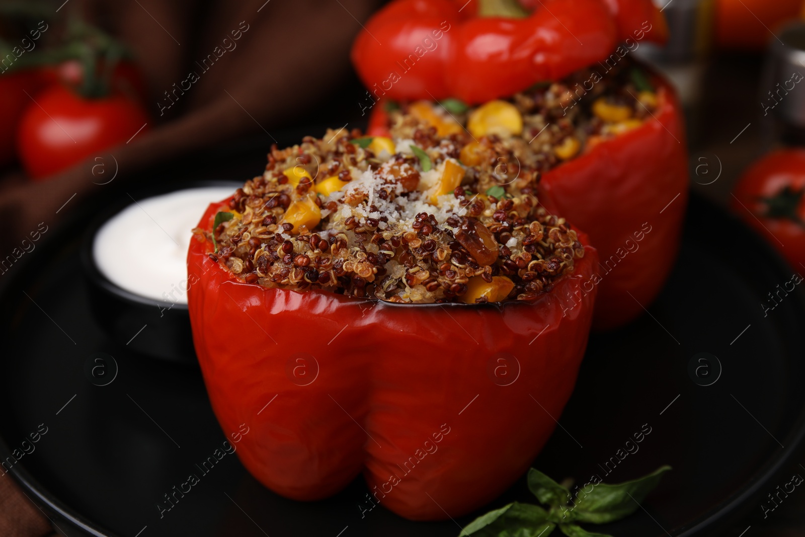 Photo of Quinoa stuffed peppers with corn and basil on table, closeup