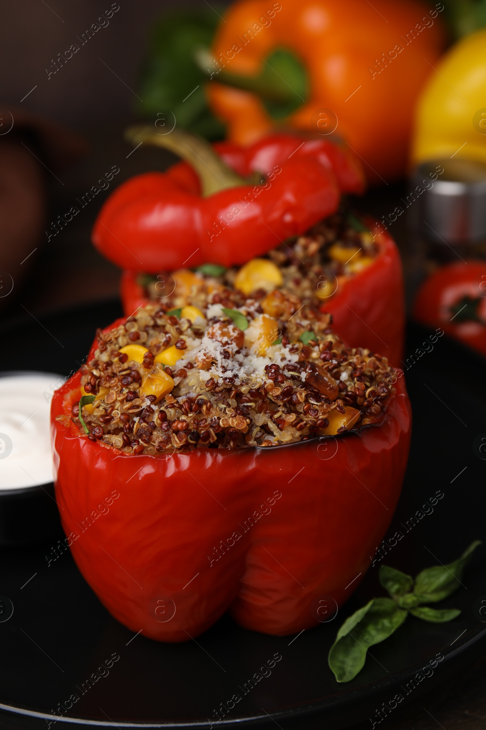 Photo of Quinoa stuffed peppers with corn and basil on table, closeup