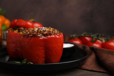 Photo of Quinoa stuffed peppers with corn on wooden table, closeup. Space for text