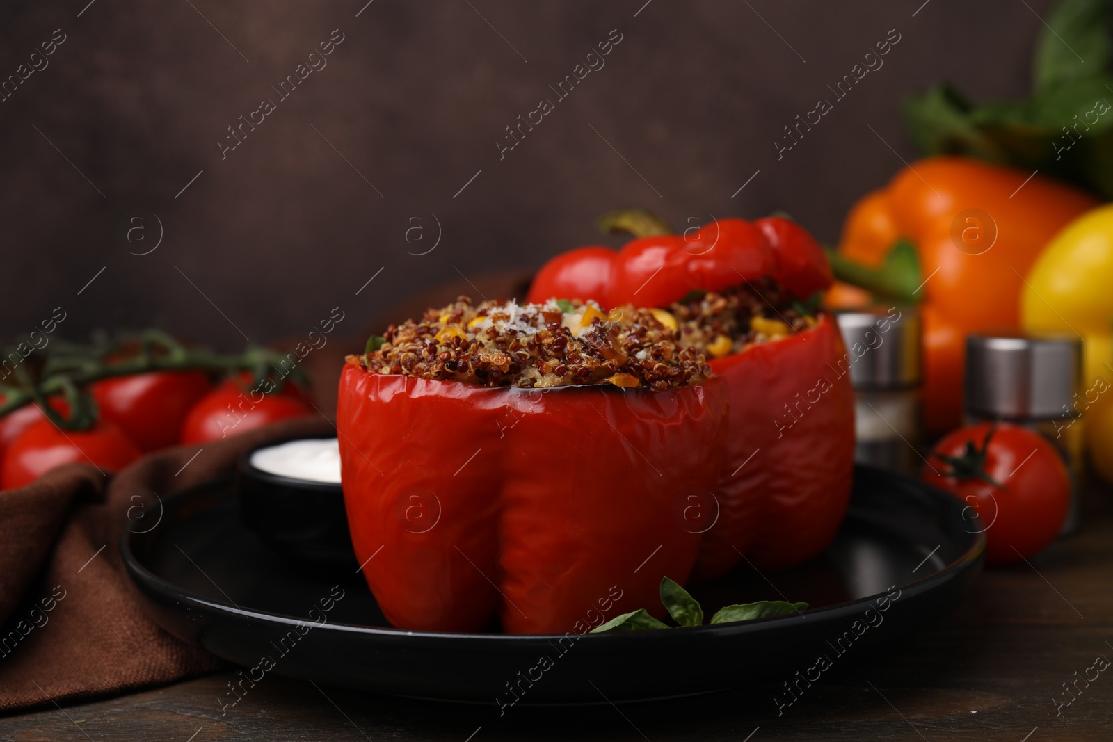 Photo of Quinoa stuffed peppers with corn and basil on wooden table