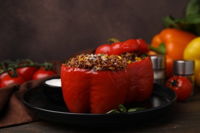 Photo of Quinoa stuffed peppers with corn and basil on wooden table