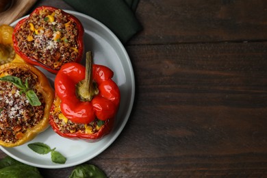 Photo of Quinoa stuffed peppers with corn and basil on wooden table, top view. Space for text