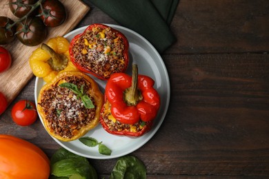 Photo of Quinoa stuffed peppers with corn and basil on wooden table, flat lay. Space for text