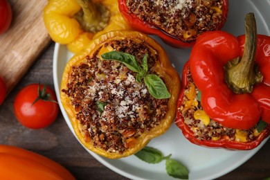 Photo of Quinoa stuffed peppers with corn and basil on wooden table, flat lay