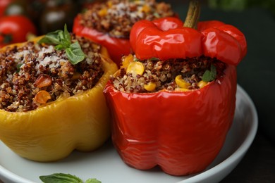 Photo of Quinoa stuffed peppers with corn and basil on table, closeup