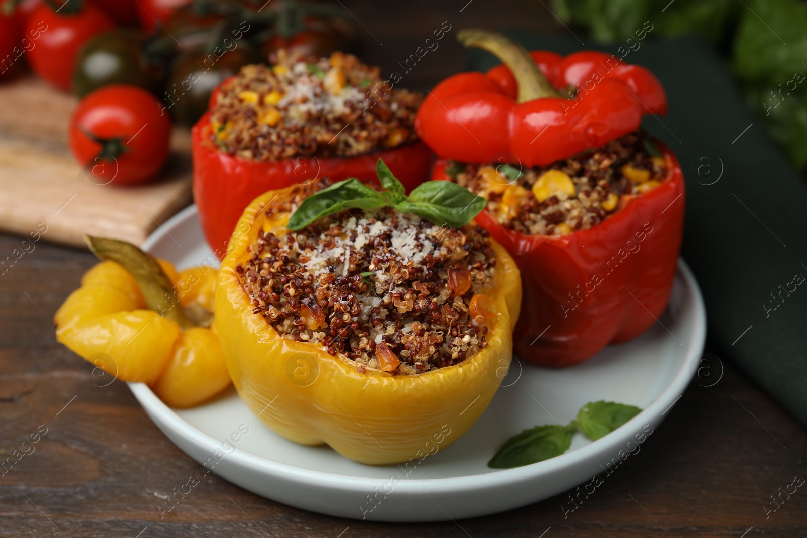 Photo of Quinoa stuffed peppers with corn and basil on wooden table