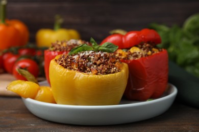 Photo of Quinoa stuffed peppers with corn and basil on wooden table