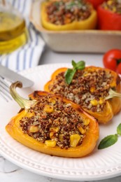 Photo of Quinoa stuffed peppers with corn and basil on white textured table, closeup