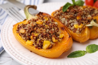 Photo of Quinoa stuffed peppers with corn and basil on white textured table, closeup