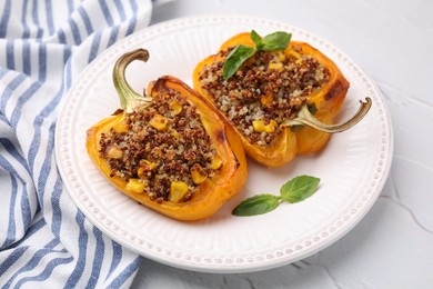 Photo of Quinoa stuffed peppers with corn and basil on white textured table