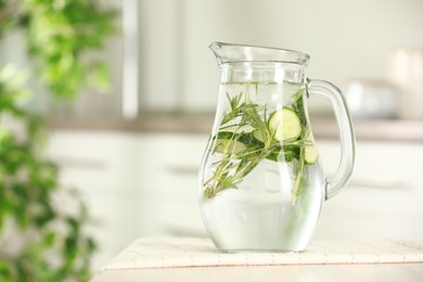 Photo of Refreshing cucumber water with rosemary in jug on white table, closeup. Space for text