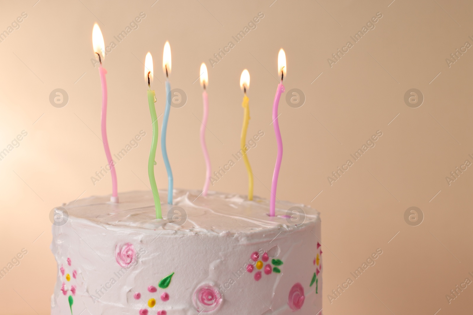 Photo of Tasty Birthday cake with burning candles against beige background, closeup