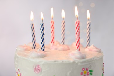 Tasty Birthday cake with burning candles against light grey background, closeup