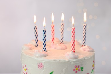 Photo of Tasty Birthday cake with burning candles against light grey background, closeup