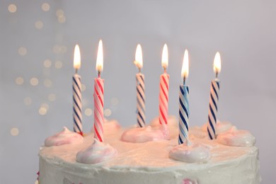 Photo of Tasty Birthday cake with burning candles against light grey background, closeup