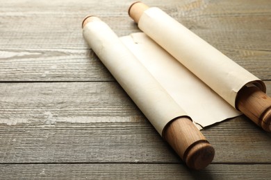 Photo of Sheet of old parchment paper with handles on wooden table, space for text