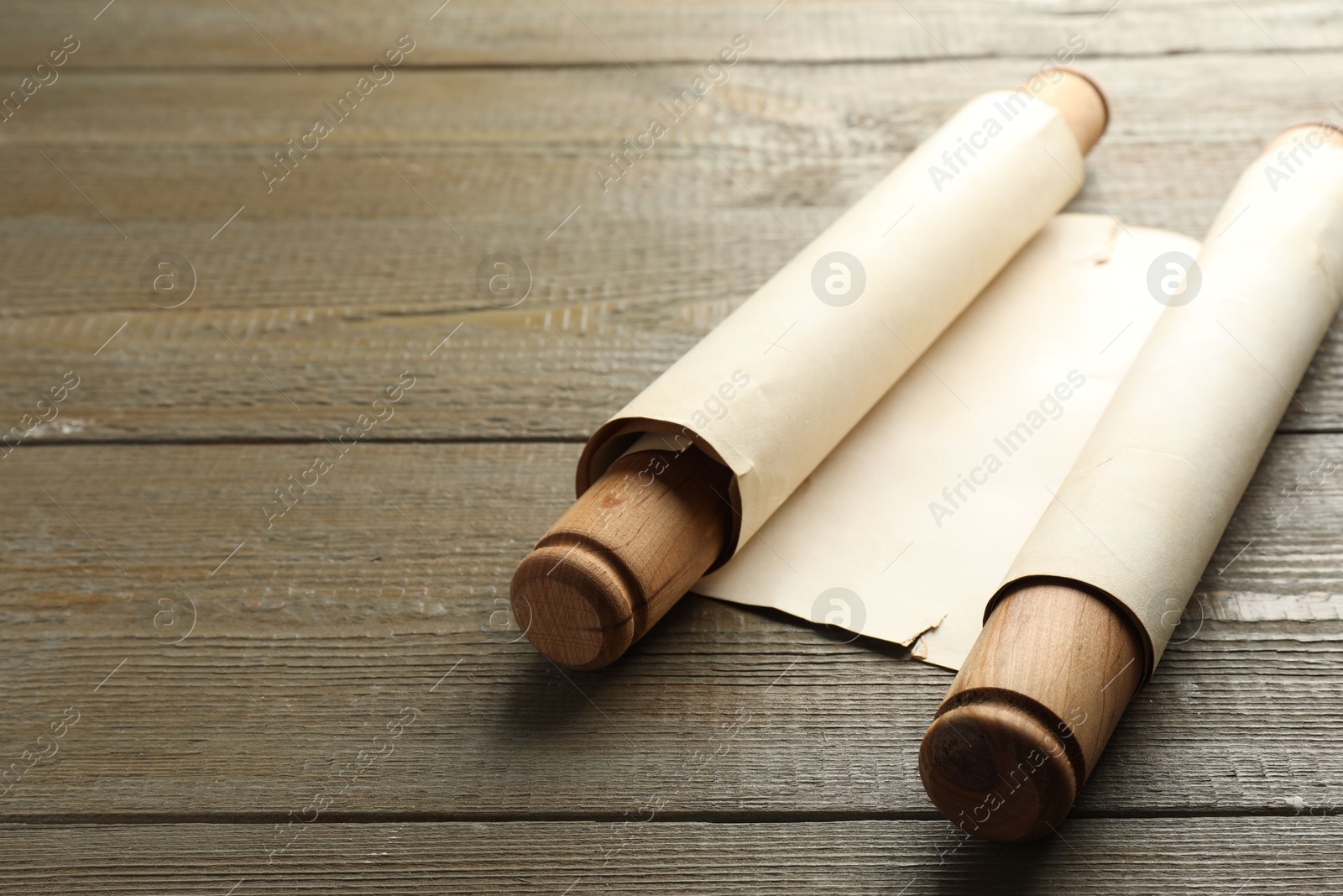 Photo of Sheet of old parchment paper with handles on wooden table, space for text