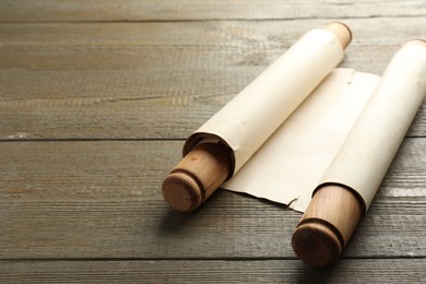 Photo of Sheet of old parchment paper with handles on wooden table, space for text