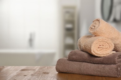 Image of Stack of fresh towels on table in bathroom. Space for text