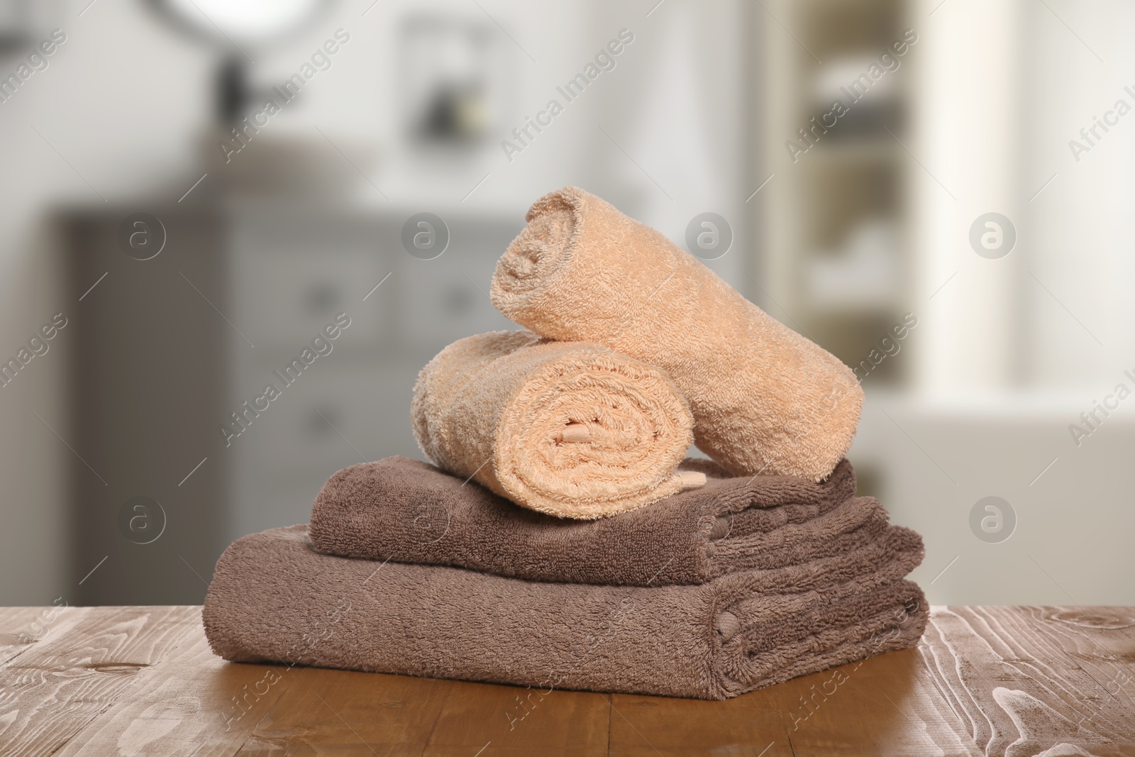 Image of Stack of fresh towels on table against blurred bathroom interior